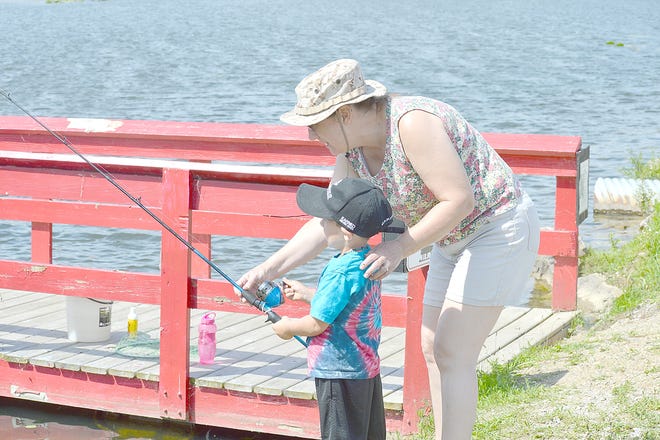 A child gets help setting his line during the fishing derby on Saturday sponsored by the Hillsdale Kiwanis and Hillsdale County Conservation Club. [SAM FRY PHOTO]