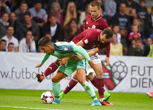Latvia's Olegs Laizans, right, and Portugal's Andre Silva fight for the ball during their World Cup Group B qualifying match between Latvia and Portugal at the Skonto Stadium in Riga, Latvia, Friday, June 9, 2017.