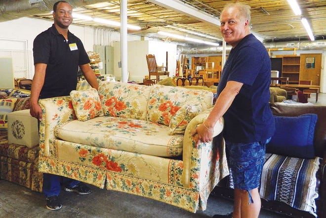 Volunteers Jeffrey DeGraffenreid, left, and Terry Brewer prepare to load a loveseat for a client.