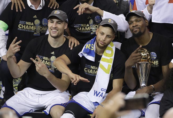 Golden State guard Klay Thompson, guard Stephen Curry and forward Kevin Durant celebrate after winning the NBA Finals against Cleveland in Oakland, California on Monday. [Marcio Jose Sanchez/The Associated Press]