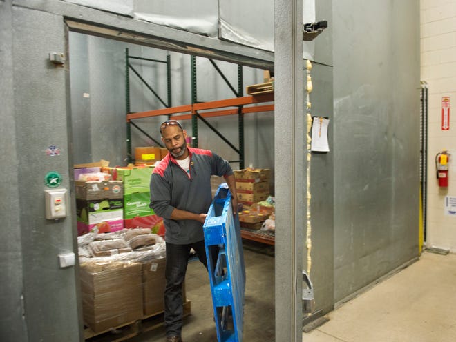 DAVID ZALAZNIK/JOURNAL STAR Peoria Area Food Bank warehouse manager Couri Thomas moves a pallet from the facility's cooler to make room for expected clients on May 24. Food bank officials are hoping to raise funds to replace the cooler and the freezer.