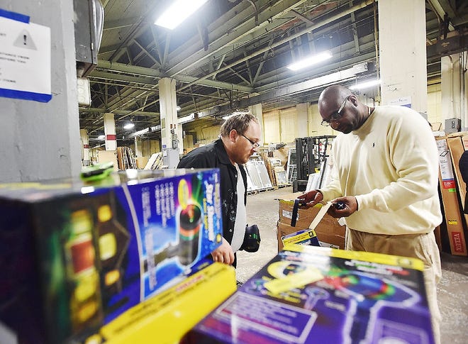 From left, Thomas Wolbert and Ricardo Pacheco go through items at the Miracle Works Warehouse on June 6 in Utica. [SARAH CONDON/OBSERVER-DISPATCH]