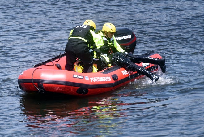 Portsmouth firefighters Rick Condon, left, and Matt Chase, pull firefighter Tammy Frechette during a practice of life-saving skills and rescue in Portsmouth Harbor on Tuesday. [Deb Cram/Seacoastonline]