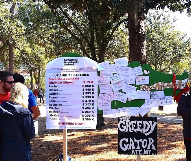 A sign listing the salaries of University of Florida administrators that was campus as part of a Graduate Assistants United campaign to address the fees charged to graduate assistants. [Submitted photo]
