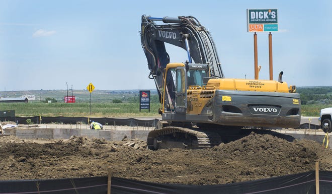 CHIEFTAIN PHOTO/CHRIS McLEAN A worker on Thursday assists with foundation work on a retail building under construction in front of Dick's Sporting Goods at the Pueblo Crossing shopping center. The building will provide space for up to seven stores.