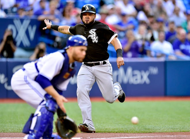 Chicago White Sox left fielder Melky Cabrera, right, beats the throw to score at home plate during the first inning of a baseball game against the Toronto Blue Jays, Friday, June 16, 2017 in Toronto. (Frank Gunn/The Canadian Press via AP)