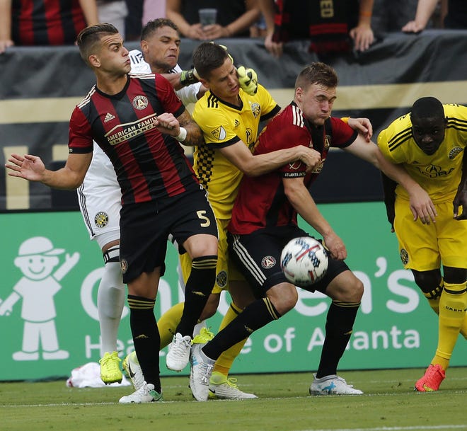 The Crew's Jukka Raitala, center, and goalkeeper Zack Steffen, rear, get tangled up with players from Atlanta. [John Bazemore/The Associated Press]