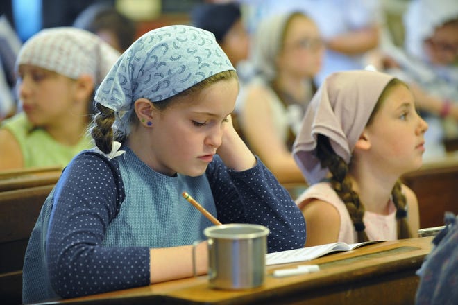 Shailagh Haley checks over her work during the Holbrook Historical Society's 1870s School Days program at the Roberts School June 7. [Wicked Local photo/Tom Gorman]