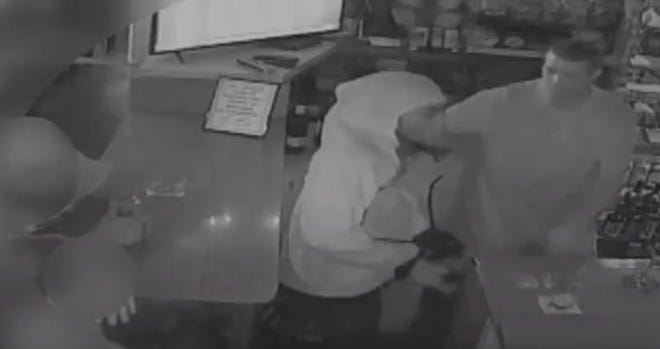 A video still showing armed robbery suspects in Memories Lounge. [From video provided by the Sarasota Police Department]