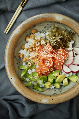 You can make your own poke bowls at home. Get the right ingredients, do a little chopping, and you have a simple, satisfying meal. You can even throw a poke party and let guests fill their bowls with the base, fish, toppings and sauce they prefer. (Juli Leonard/Raleigh News & Observer/TNS)