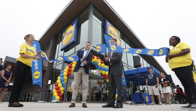 Brendan Proctor, the U.S. chief executive of Lidl, center left, and Virginia Secretary of Commerce and Trade Todd Haymore, center right, cut a ribbon during the grand opening of a Lidl grocery store in Virginia Beach, Va., on Thursday. Several Lidl stores opened across the nation last week.