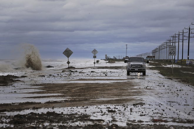 Vehicles navigate past waves and debris washing over State Highway 87 as Tropical Storm Cindy approaches Wednesday in High Island, Texas. [MICHAEL CIAGLO / ASSOCIATED PRESS]