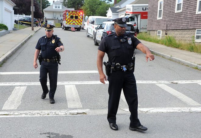 Fall River police Sgt. William Flanders and Patrolman Derrick Silvia look for evidence on Lamphor Street.after a shooting on Wednesday evening.
