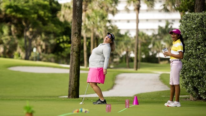 Rebecca Seelig, left, of Palm Beach Gardens and volunteer Vrishti Patel, 12, of Lake Worth laugh as a ball misses a hole during a putting challenge at the beginning of the Executive Women’s Golf Association Par 3 Challenge last year. Meghan McCarthy / Daily News