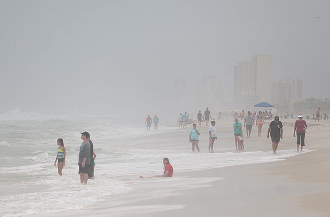 Beachgoers look at the stormy water Wednesday at the M.B. Miller County Pier in Panama City Beach. Double-red flags were posted much of the day. See more photos and video at newsherald.com. [PATTI BLAKE/THE NEWS HERALD]
