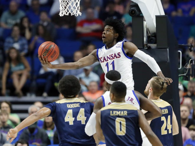 FILE - In this March 17, 2017, file photo, Kansas's Josh Jackson (11) goes up for a shot over UC Davis's Garrison Goode (44), Brynton Lemar (0) and Mikey Henn (24) in the first half of a first-round game in the men's NCAA college basketball tournament in Tulsa, Okla. Jackson spent one season at Kansas and is expected to be a top-five pick in Thursday's NBA draft. (AP Photo/Tony Gutierrez, File)