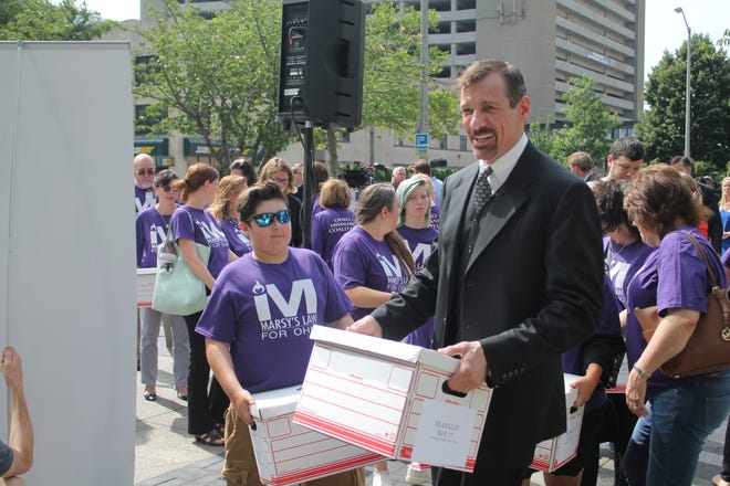 Marsy’s Law founder Henry Nicholas and other supporters of the proposed victims right constitutional amendment help carry boxes of petitions into the Ohio secretary of state’s office Thursday in Columbus. (GateHouse Ohio Media / Marc Kovac)