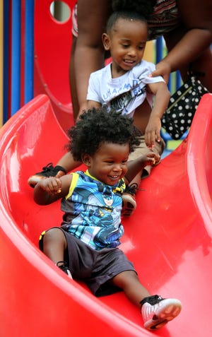 Kaelon Archie, 1, and Zy'mir Archie, 2, take turns sliding at Shelby City Park on Wednesday. [Brittany Randolph/The Star]