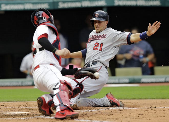 Minnesota Twins' Jason Castro scores ahead of the tag by Cleveland Indians catcher Roberto Perez during the second inning of a baseball game, Friday, June 23, 2017, in Cleveland. (AP Photo/Tony Dejak)