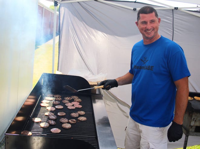 Mike Pidd manned the grill during a benefit dinner for Pittsford student Gabe Way on Tuesday. Way was struck by a car while riding his bicycle earlier this month. [ANDREW KING PHOTO]