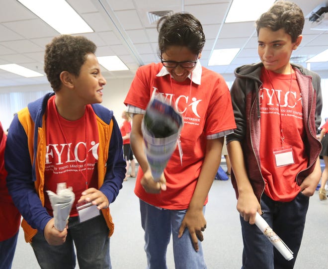 Brothers Muhammed Elyaman, 12, left, and Adnan Elyaman, 13, right, take part in an enthusiastic exercise Friday with Amir Bacchus, 13, center, during the Fakhoury Young Leaders Conference at the College of Central Florida Hampton Center in Ocala. The two day conference featured 13 speakers and taught young people about leadership with an emphasis on community collaboration, goal setting, life balance and philanthropy, to name a few. [Bruce Ackerman/Staff photographer]