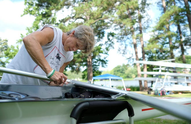Women’s Single D participant Cathy Dowhos-O’Gorman attaches rigging to her boat Saturday.