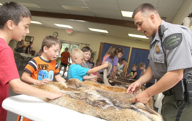 Michigan Conservation Officer Issac Tyson talks with children Friday morning about different furs. Tyson who serves Branch and Hillsdale Counties was the guest speaker at the Litchfield District Library’s summer reading program. [ANDY BARRAND PHOTO]