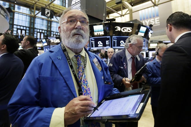Trader Eugene Mauro, left, works on the floor of the New York Stock Exchange last week as traders were keeping a close eye on the dropping price of oil. [AP /Richard Drew]