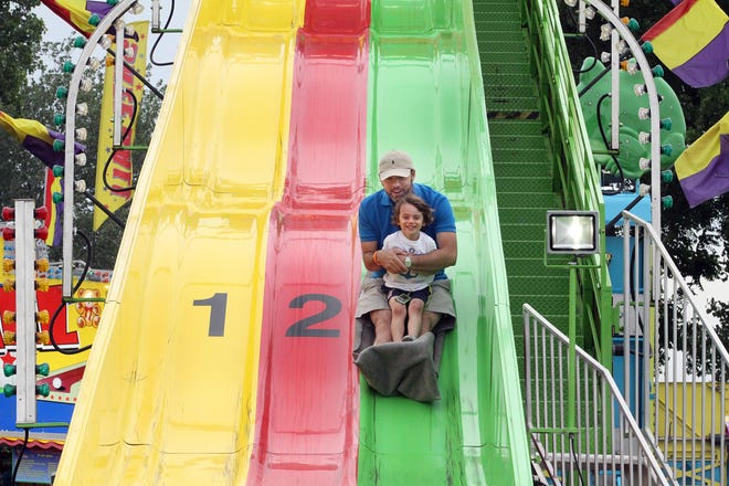Jay Gilbert hangs onto his son Benton as they slide down a ride during Old Settlers Days on June 20, 2015, at Settlers Park in Rockton. [815, RRSTAR.COM & THE JOURNAL-STANDARD FILE PHOTO]