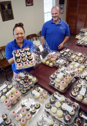 Michelle Parmeter, an EMT and secretary at Mortlake Fire Company in Brooklyn, and Fire Chief Steve Breen with some of the 1,800 cupcakes sold Saturday to raise money for defibrillators for the town's recreation fields. See videos and more photos at NorwichBulletin.com [John Shishmanian/ NorwichBulletin.com]