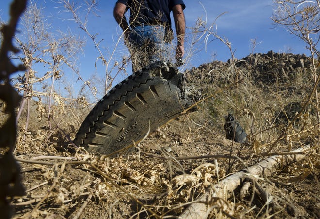 Kerry Henard walks by a partially buried tire at Horseman's Center Park in Apple Valley. Henard started a YouTube channel devoted to exposing what he sees as the town's ineptitude and hypocrisy. [JAMES QUIGG, DAILY PRESS]