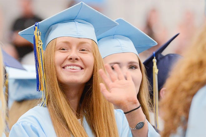 Central Valley Academy graduate Nicole Pickett waves as she takes her seat in the gymnasium during graduation on Friday in Ilion. [ALEX COOPER/OBSERVER-DISPATCH]