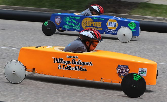 Collin Smith (orange) and Caleb Shamp (blue) race down Main Street in Sugarcreek Sunday during the Stock Division of the Tuscarawas County Soap Box Derby. (TimesReporter.com / Jim Cummings)