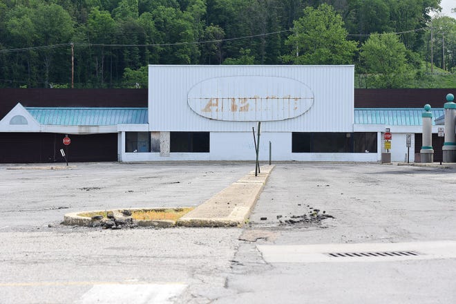 A deteriorating parking lot sits in front of a long-vacant storefront in the Northern Lights shopping center. The owner of the shopping center has applied for demolition permits to tear down parts of the plaza.