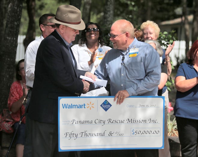 David Henry, right, presents a check for $50,000 to Thurman Chambers on Monday at the Panama City Rescue Mission. [PATTI BLAKE/THE NEWS HERALD]