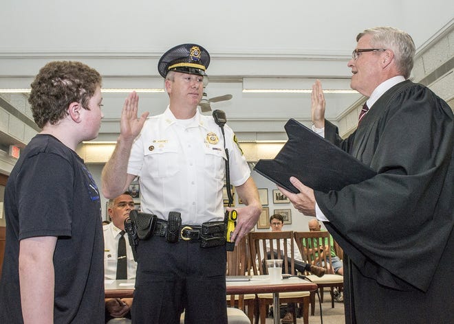 Randolph Lt. Jeffrey Chaplin is sworn in to his new position by Town Clerk and Assistant Town Manager Brian Howard. Chaplin's son, Sean, 14, looks on. [Wicked Local photo/Bob Michelson]