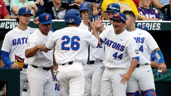 Florida players congratulate Nick Horvath (26) after he scored on a base hit by Deacon Liput during the second inning of their College World Series game on Tuesday against LSU in Omaha, Neb. (AP Photo/Nati Harnik)