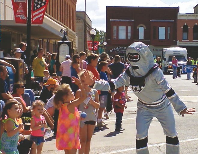 A robot makes its way along the Heritage Days parade route on Saturday, giving “high-fives” to children.