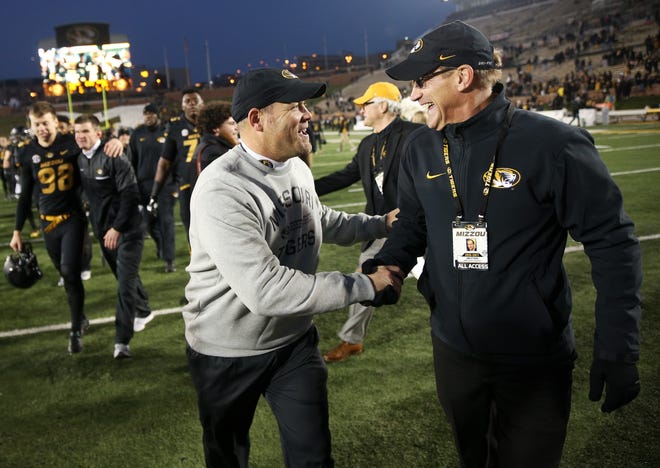 Missouri football coach Barry Odom, left, shakes hands with athletic director Jim Sterk after a victory over Arkansas last season. Missouri reported on Wednesday that it raised $50.4 for the Tiger Scholarship Fund during the 2016-17 fiscal year, a school-record amount. Sterk started as Missouri's AD in August. [Tribune file photo]