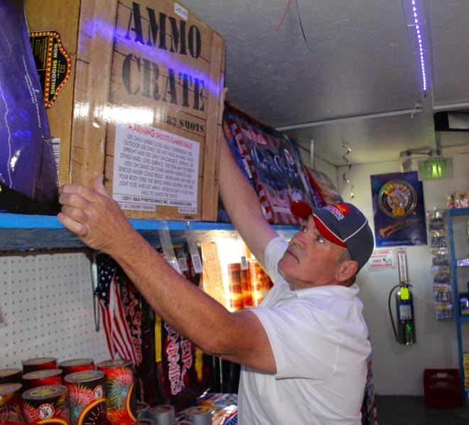 Pyroblast Fireworks owner Ray Phillips pulls a big box of pyrotechnics off the shelf. [ANDREW KING PHOTO]