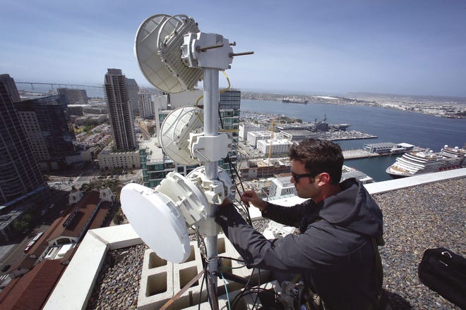 Webpass technician Adam Larnach installs an upgraded millimeter wave radio on the roof top of a high rise condo unit in downtown San Diego, Calif. The upgraded piece of hardware will increase internet bandwidth for download and upload.