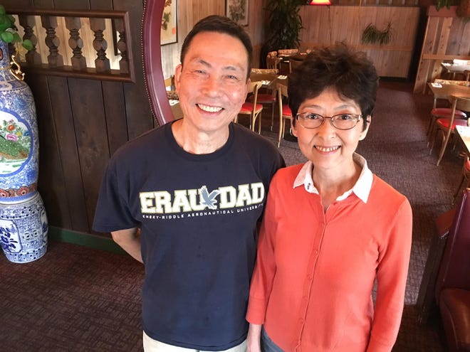 Ken and Morales Chan on Wednesday stand in the dining room of Jade Palace Restaurant just before opening for their last day of business. The couple had owned and operated the restaurant at 906 W. Seventh Ave. since 1984.(Ed Russo/The Register-Guard)