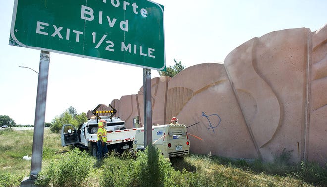 CDOT workers use a sand blaster to remove MOP graffiti from the decorative wall along Colorado 47 recently. A lot of work on the wall remains.