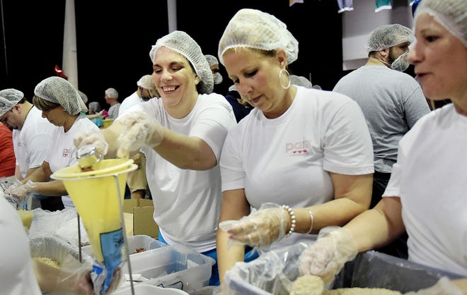 Tracey McAllistar, center, and other volunteers from Parx Casino work in assembly line fashion Friday, June 30, 2017, at Delaware Valley University in Doylestown Township to pack shelf-stable meals to be distributed to food pantries in Bucks County this summer. The BKO effort is a community-driven hunger fighting event that provides 100,000 meals, 54,000-plus pounds of local produce, and important perishables (milk, butter and cheese) to people in need in Bucks County.