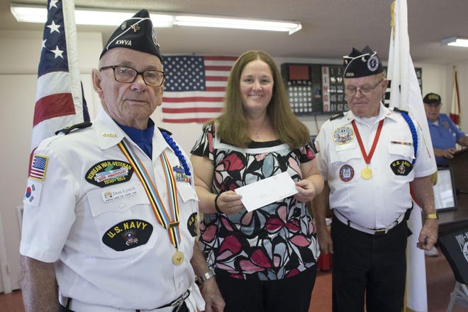 Chaplain DJ Lynch, left, and Joe Briggs present April Jedziniak, center, owner of the Sumter County Golden Corral, a check for $2,000 at the Korean War Veteran Association meeting on Wednesday. [CINDY DIAN / CORRESPONDENT]
