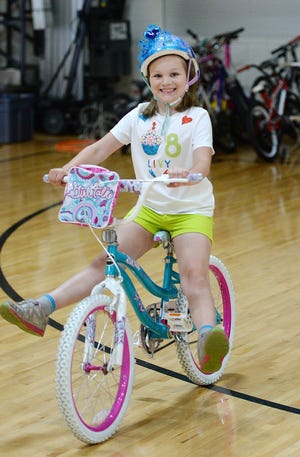Olivia Elwell, 8, of North East, shows off her riding skills during the Learn to Ride Bike Camp at the Barber National Institute on Saturday. [JACK HANRAHAN/ERIE TIMES-NEWS]