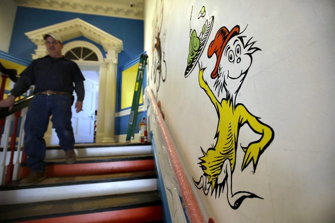 In this May 4, 2017, photo a man walks past a mural with the character "Sam-I-Am" from the Dr. Seuss book "Green Eggs and Ham" at The Amazing World of Dr. Seuss Museum, in Springfield, Mass. 

(AP Photo/Steven Senne)
