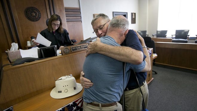 In this June 26, 2015, file photo, Gerald Gafford, right, holds his partner of over 28 years, Jeff Sralla, after he was overcome with emotion when Travis County state District Judge Amy Clark Meachum said she would sign the 72-hour waiting period waiver after the Supreme Court ruling allowing same sex marriage in the U.S.