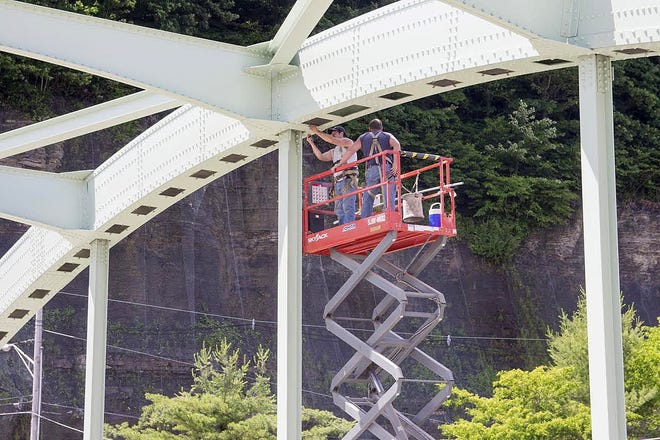 Workers install lighting on the Center Street Bridge in Oil City. [CONTRIBUTED]