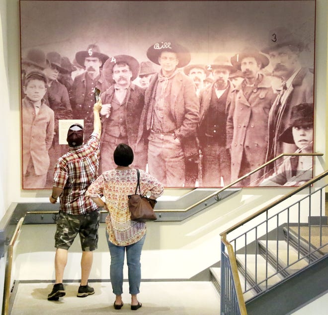 Jason and Holly Engle of Clarksville identify some of the members of the posse and deputies that captured the outlaw, Cherokee Bill, January 30, 1895, in Wagoner, Okla., from a photo on display in the Fort Smith National Historic Site. The Engles were on a day trip Saturday, July 1, 2017, to the Fort Smith National Historic Site and Fort Smith Museum of History. [JAMIE MITCHELL/TIMES RECORD]